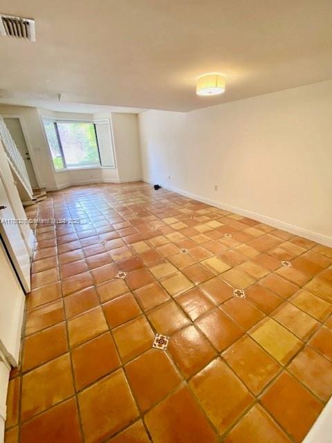 tiled spare room with baseboards and visible vents