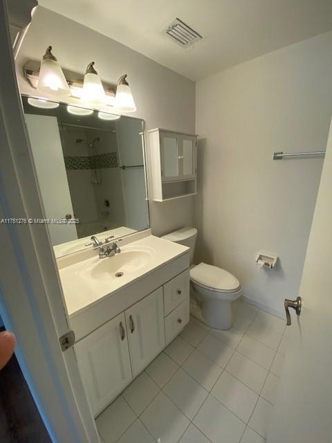 full bath with shower / bathtub combination, toilet, vanity, visible vents, and tile patterned floors