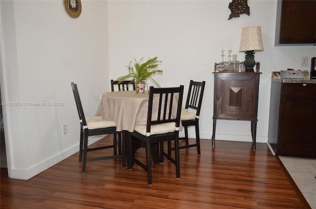 dining area featuring dark wood-style floors and baseboards