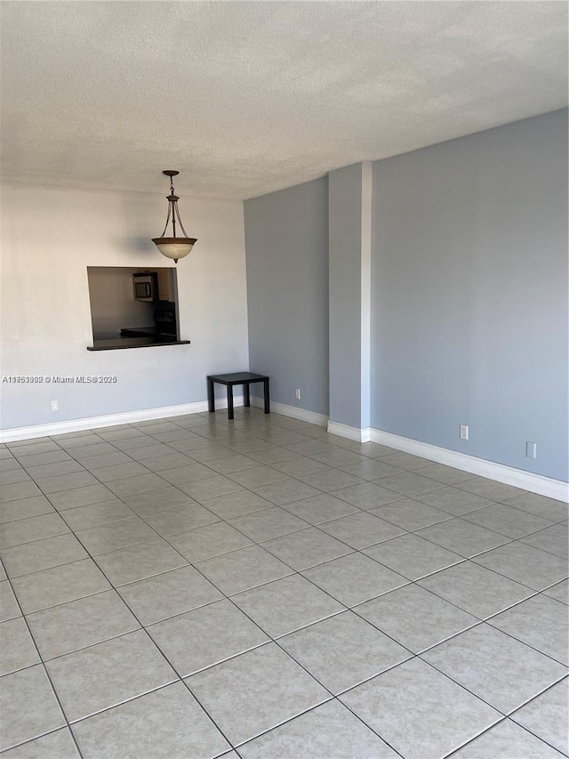 unfurnished room featuring baseboards and a textured ceiling