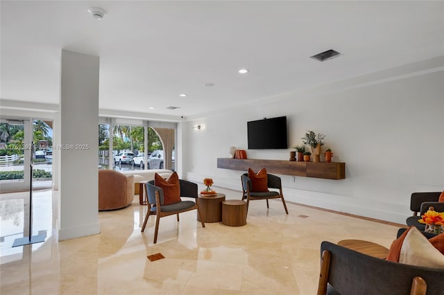 living room with a wealth of natural light, visible vents, baseboards, and recessed lighting