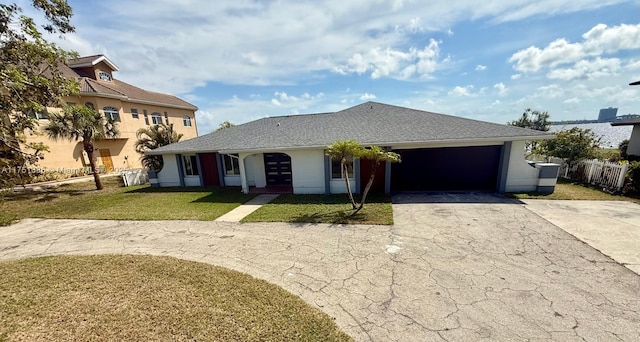 view of front of home with aphalt driveway, stucco siding, an attached garage, a front yard, and fence