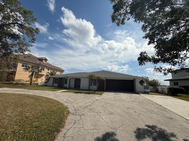 view of front of home with driveway, an attached garage, and a front yard