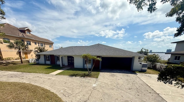 ranch-style house with aphalt driveway, stucco siding, fence, a garage, and a front lawn