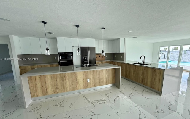 kitchen featuring marble finish floor, black appliances, a sink, and white cabinetry