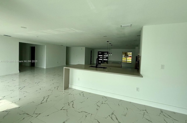 interior space with marble finish floor, decorative light fixtures, a sink, and visible vents