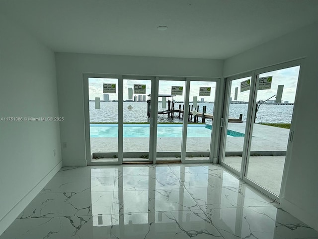 empty room featuring marble finish floor and baseboards