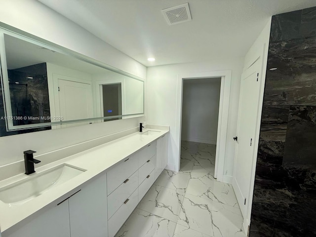 bathroom with marble finish floor, visible vents, a sink, and double vanity