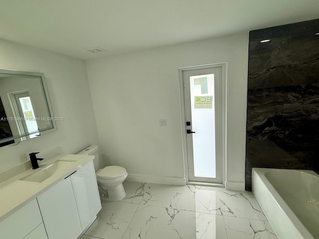 full bathroom with a bathtub, marble finish floor, toilet, a healthy amount of sunlight, and vanity