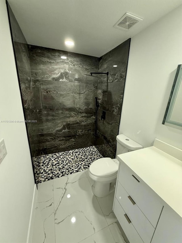 full bath with marble finish floor, a marble finish shower, visible vents, toilet, and vanity