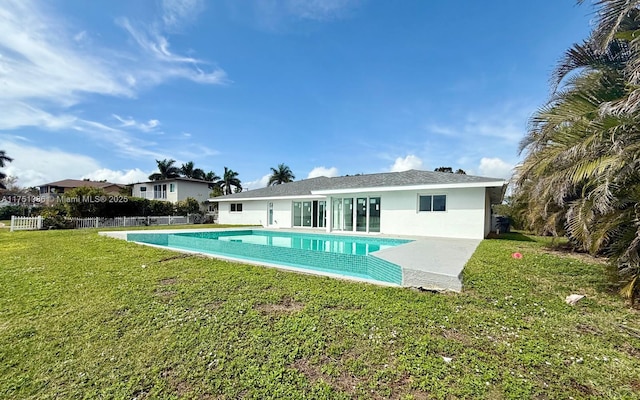 pool featuring fence and a yard