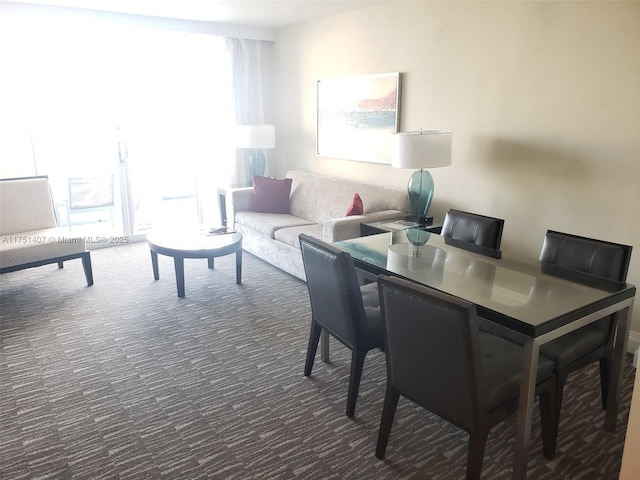 dining space with dark carpet and a wealth of natural light