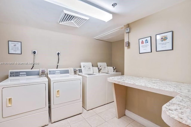 shared laundry area with washer and dryer, visible vents, and light tile patterned floors