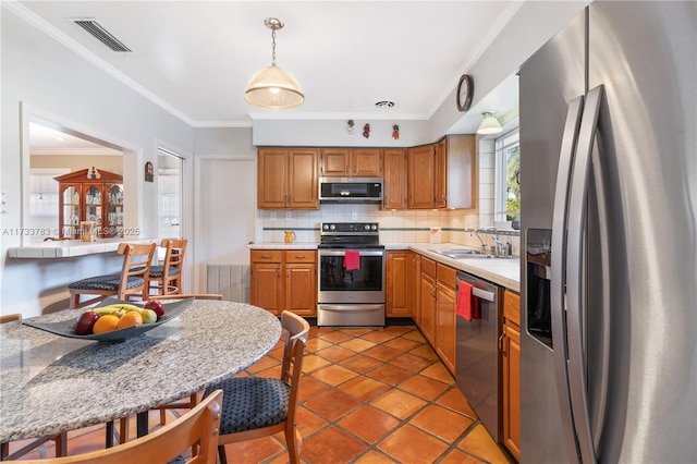 kitchen with light countertops, visible vents, decorative backsplash, appliances with stainless steel finishes, and a sink