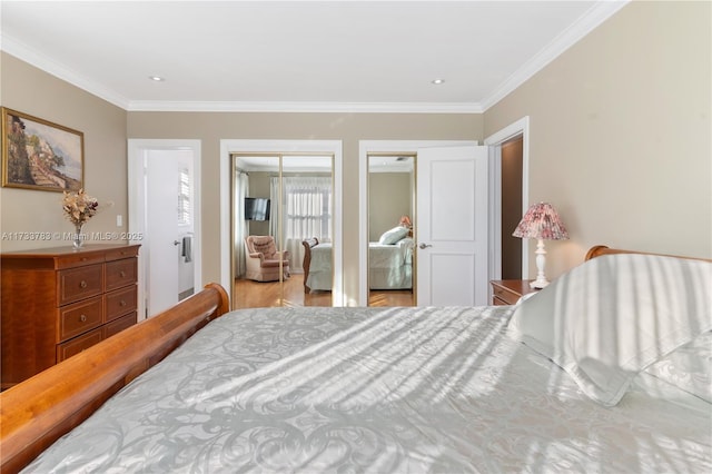 bedroom with ornamental molding and multiple closets