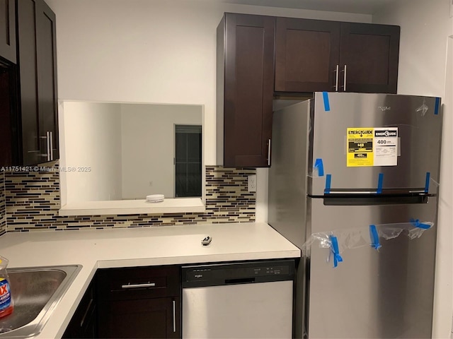 kitchen with stainless steel appliances, tasteful backsplash, light countertops, and dark brown cabinetry