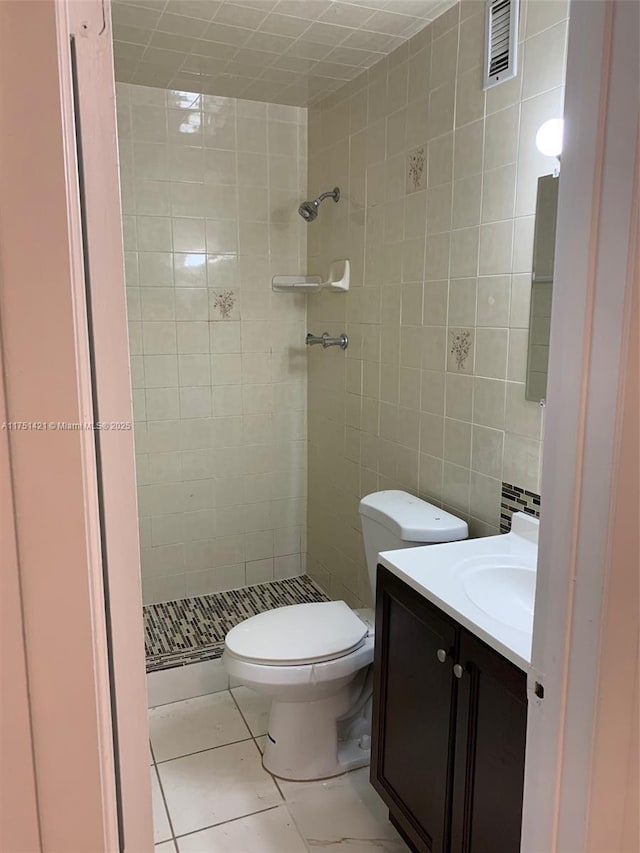 full bathroom with a stall shower, visible vents, toilet, vanity, and tile walls