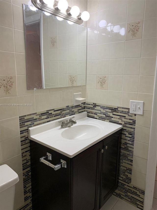 bathroom featuring decorative backsplash, toilet, tile walls, and vanity