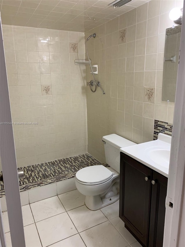 bathroom with a stall shower, tile walls, toilet, and vanity