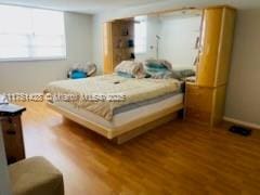 bedroom featuring wood finished floors and baseboards