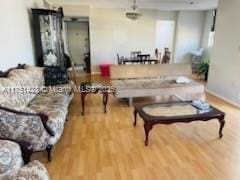 living area with baseboards and wood finished floors