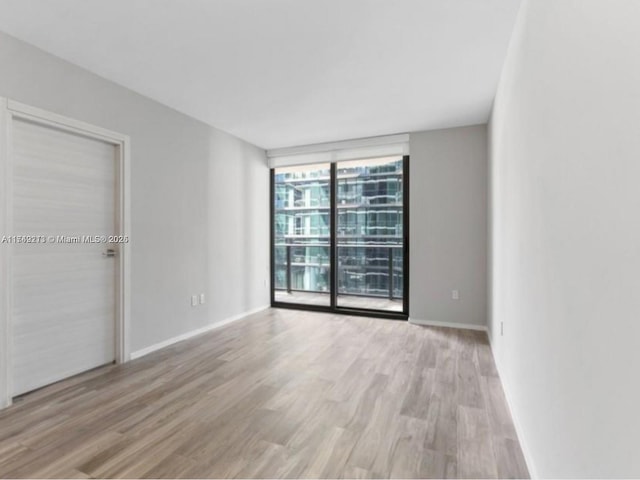 801 S Miami Ave Unit 1808, Miami, FL 33130 - unfurnished bedroom with light wood-style floors, a wall of windows, and access to exterior