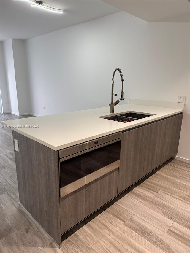 801 S Miami Ave Unit 1808, Miami, FL 33130 - kitchen with light countertops, light wood-style floors, dark brown cabinetry, and wine cooler