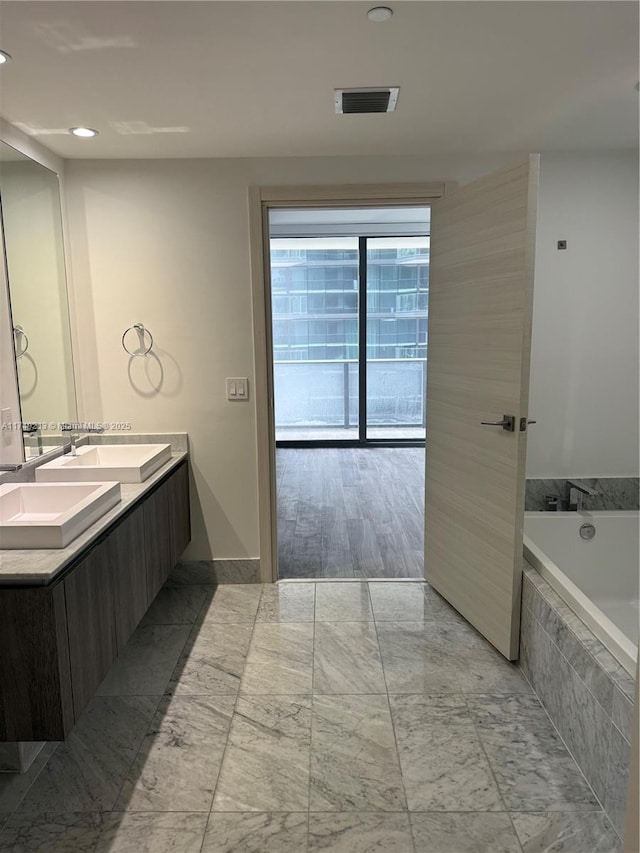 801 S Miami Ave Unit 1808, Miami, FL 33130 - full bathroom featuring double vanity, a garden tub, marble look tile flooring, and recessed lighting