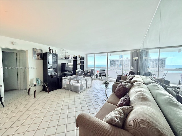 living room with a wall of windows and light tile patterned floors