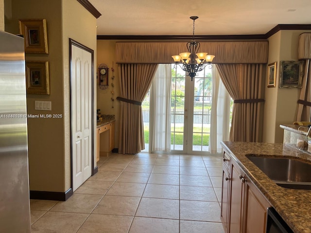 kitchen with dishwasher, ornamental molding, light tile patterned flooring, stainless steel refrigerator, and a sink