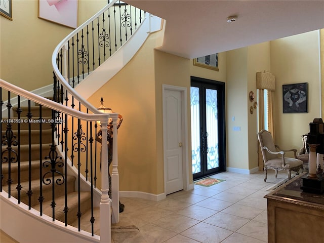 entryway with tile patterned floors, french doors, and baseboards