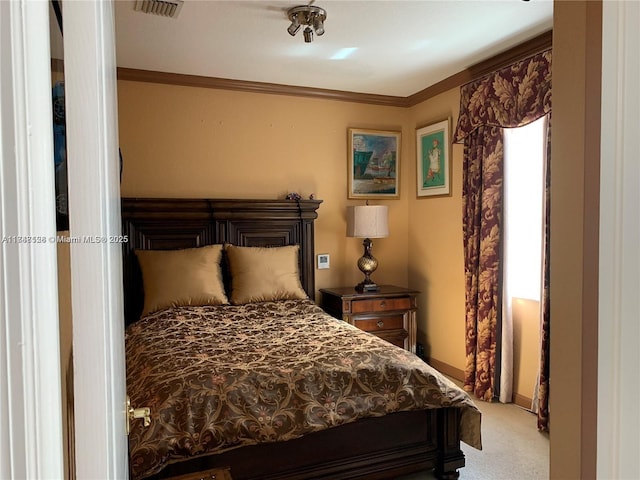 carpeted bedroom featuring visible vents and ornamental molding