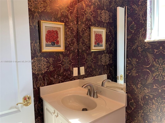 bathroom with wallpapered walls and vanity