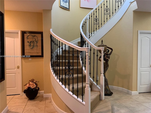 stairs featuring tile patterned floors and baseboards