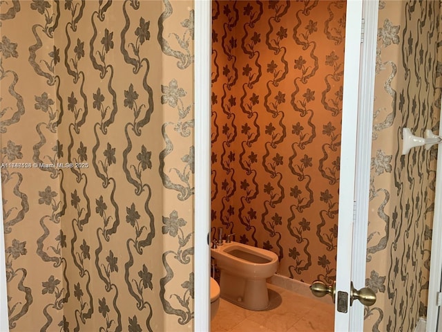 bathroom featuring tile patterned floors, toilet, and a bidet