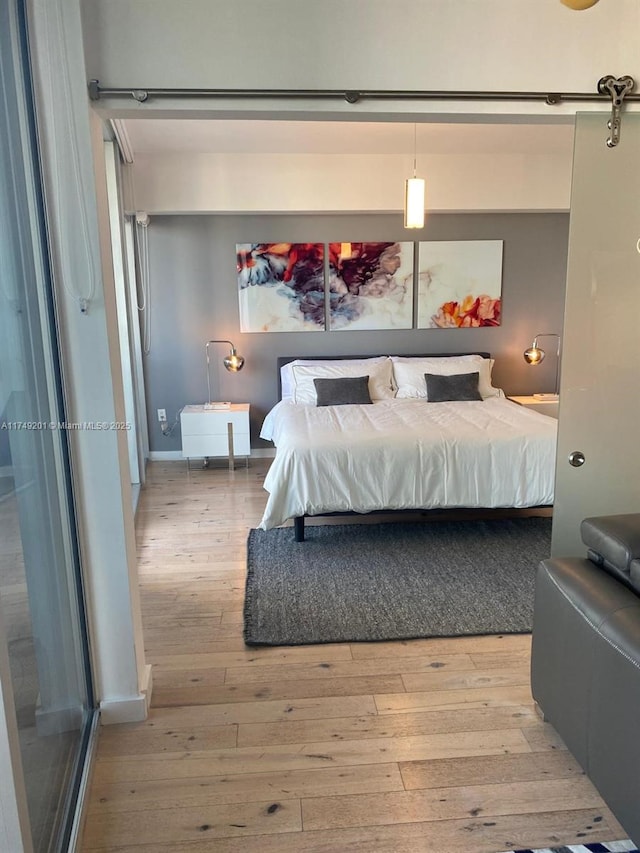 bedroom featuring baseboards and light wood-type flooring