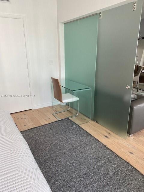 interior space with a closet, visible vents, and wood finished floors