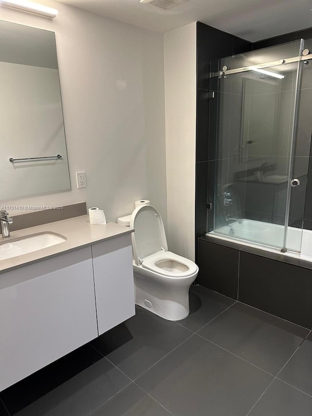 full bathroom featuring visible vents, toilet, enclosed tub / shower combo, tile patterned floors, and vanity