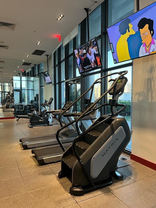 workout area with baseboards, expansive windows, and visible vents