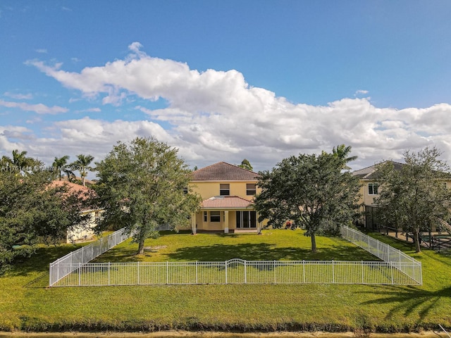 view of front of house featuring fence private yard, a front lawn, and stucco siding