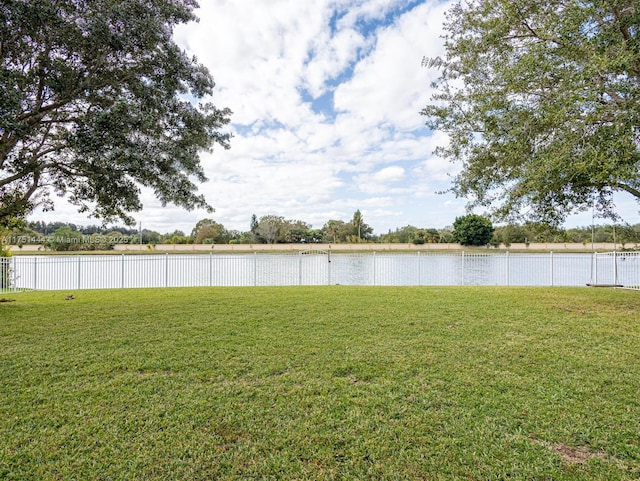 view of yard featuring a water view and fence