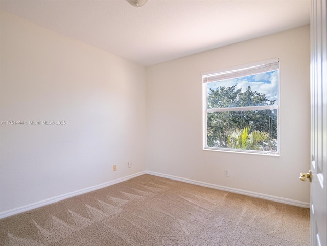 empty room featuring carpet flooring and baseboards