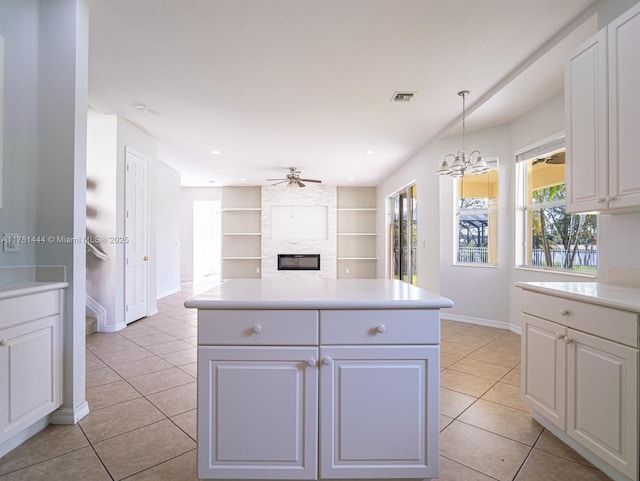 kitchen with hanging light fixtures, light countertops, and white cabinetry