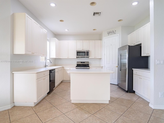 kitchen with appliances with stainless steel finishes, light countertops, a kitchen island, and visible vents