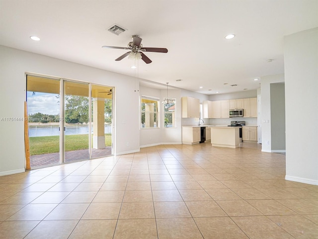 unfurnished living room featuring baseboards, visible vents, a ceiling fan, a water view, and recessed lighting