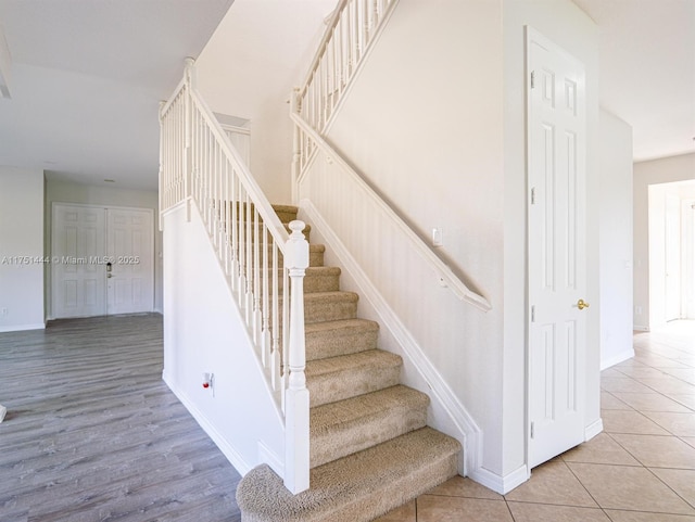 staircase featuring tile patterned flooring and baseboards