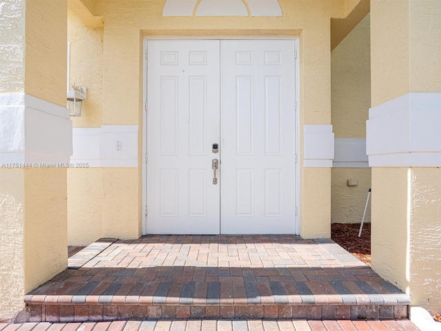 entrance to property with stucco siding