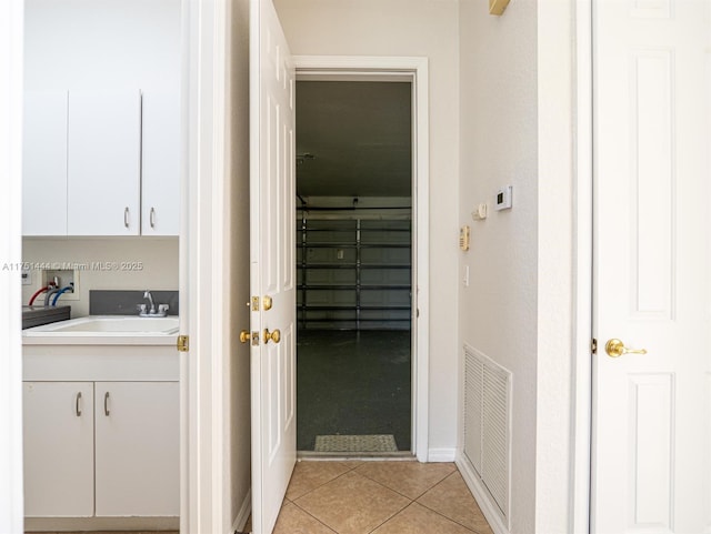 interior space featuring baseboards, vanity, visible vents, and tile patterned floors