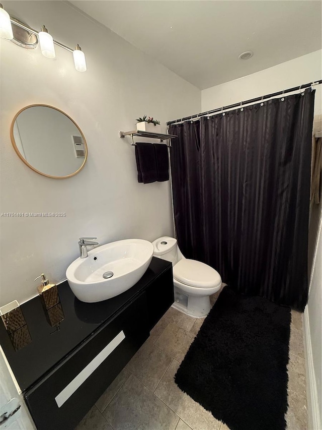 full bath featuring a shower with shower curtain, a sink, toilet, and tile patterned floors