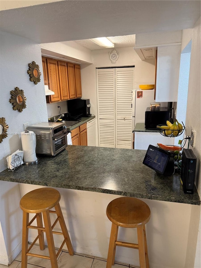 kitchen featuring dark countertops and a breakfast bar area